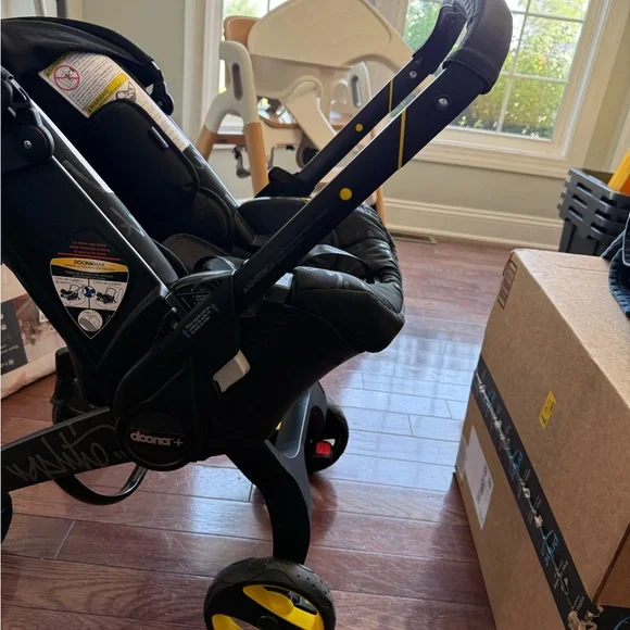 Doona Infant Car Seat & Stroller in Black with Yellow Accents - Picture 3 of 9